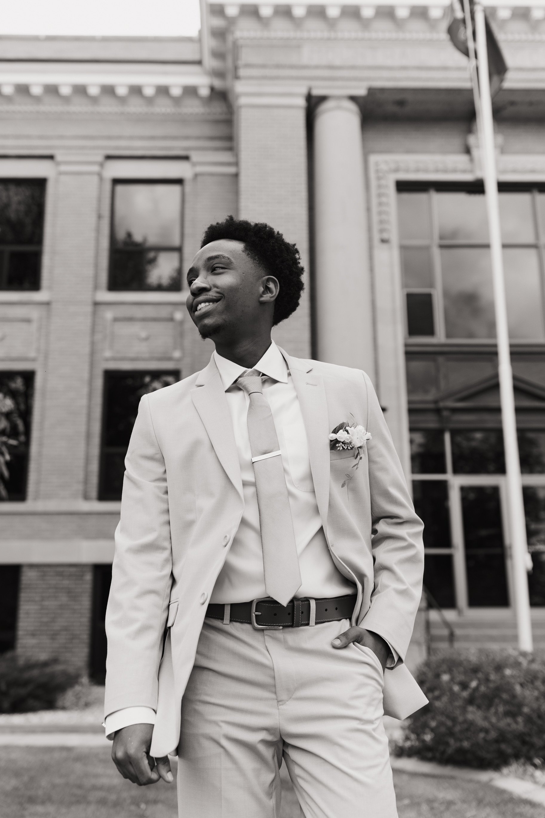 Black and white portrait of Joel Ngorimo outside a courthouse