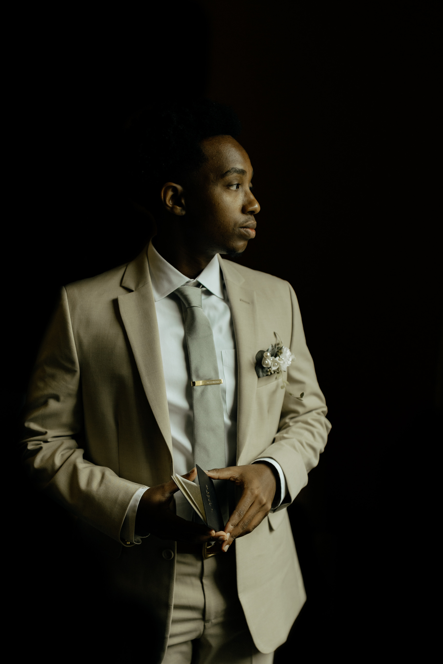 Joel Ngorimo in a studio portrait holding a book